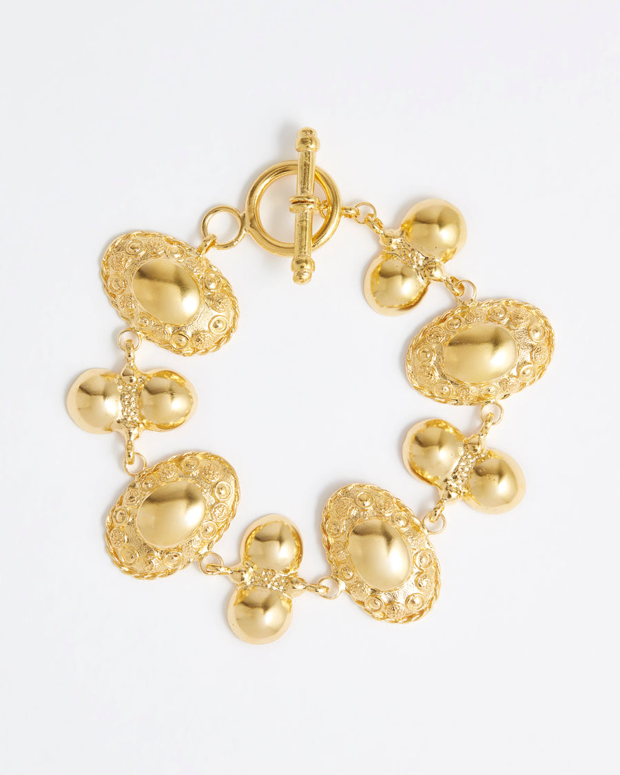 Over view image of a gold ornate link bracelet with toggle fastening from the Daphne Oz X Soru Collaboration 