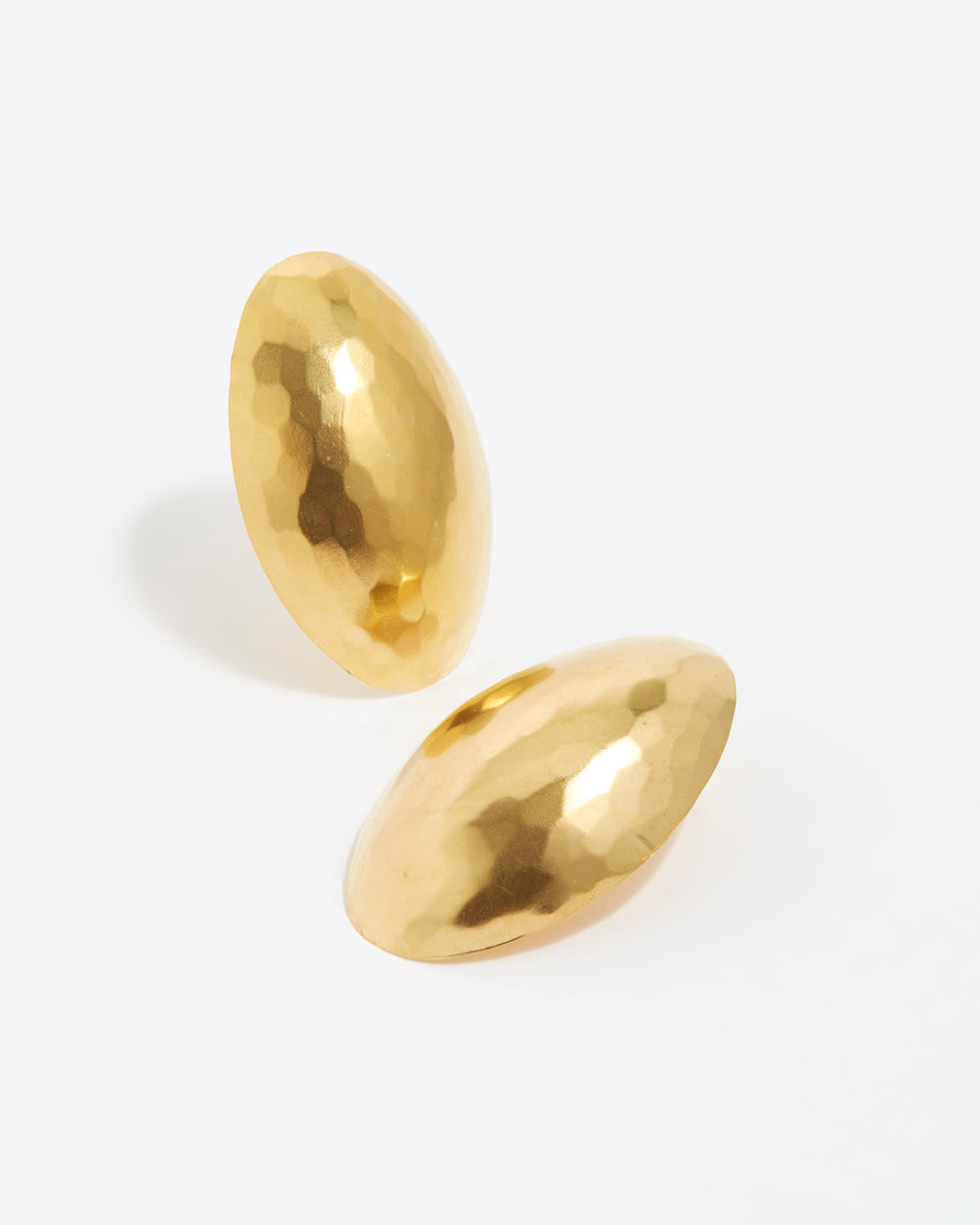 close up image shot of oversized gold oval textured earrings on a white back ground