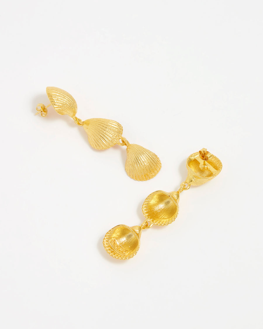 overhead product shot of gold 3 drop shell earrings lying flat and showing reverse side, on a white background.