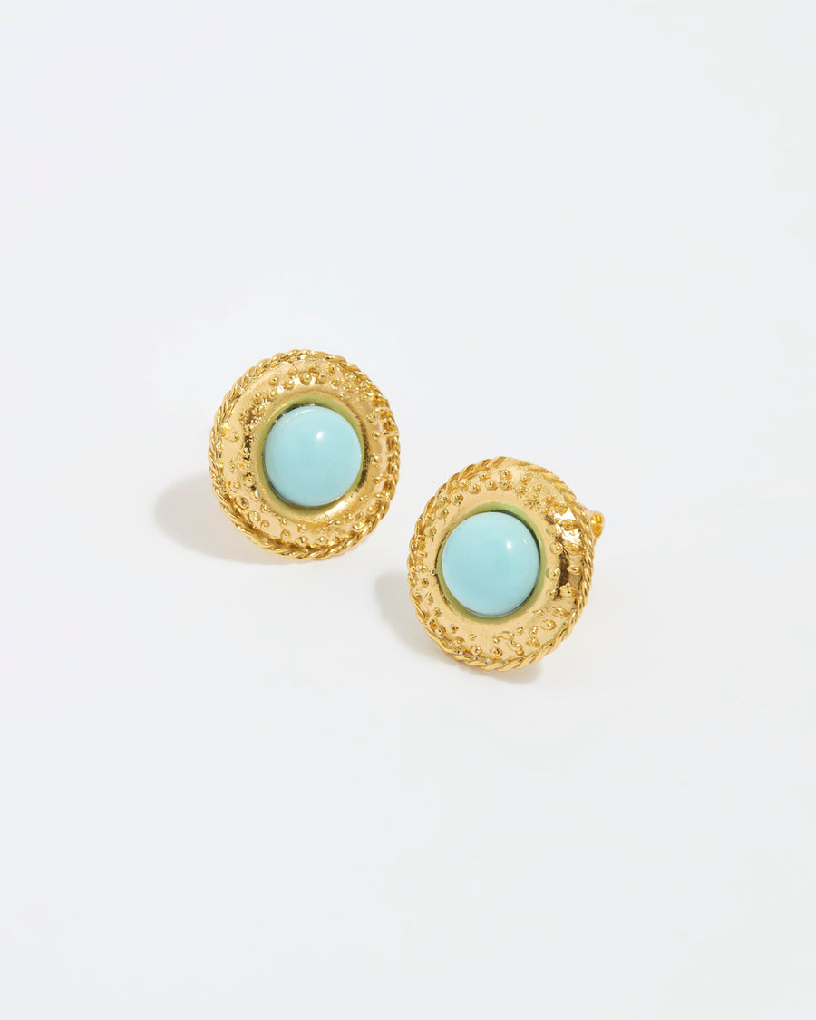 close up image shot of round gold textured stud earrings with a round turquoise centre on a white back ground