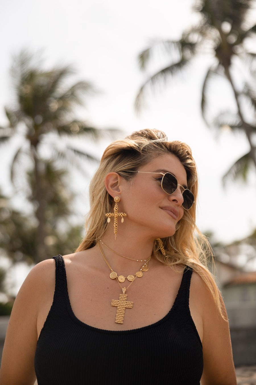 Daphne Oz wearing gold cross pendant and gold cross earrings while outside from her collaboration with soru