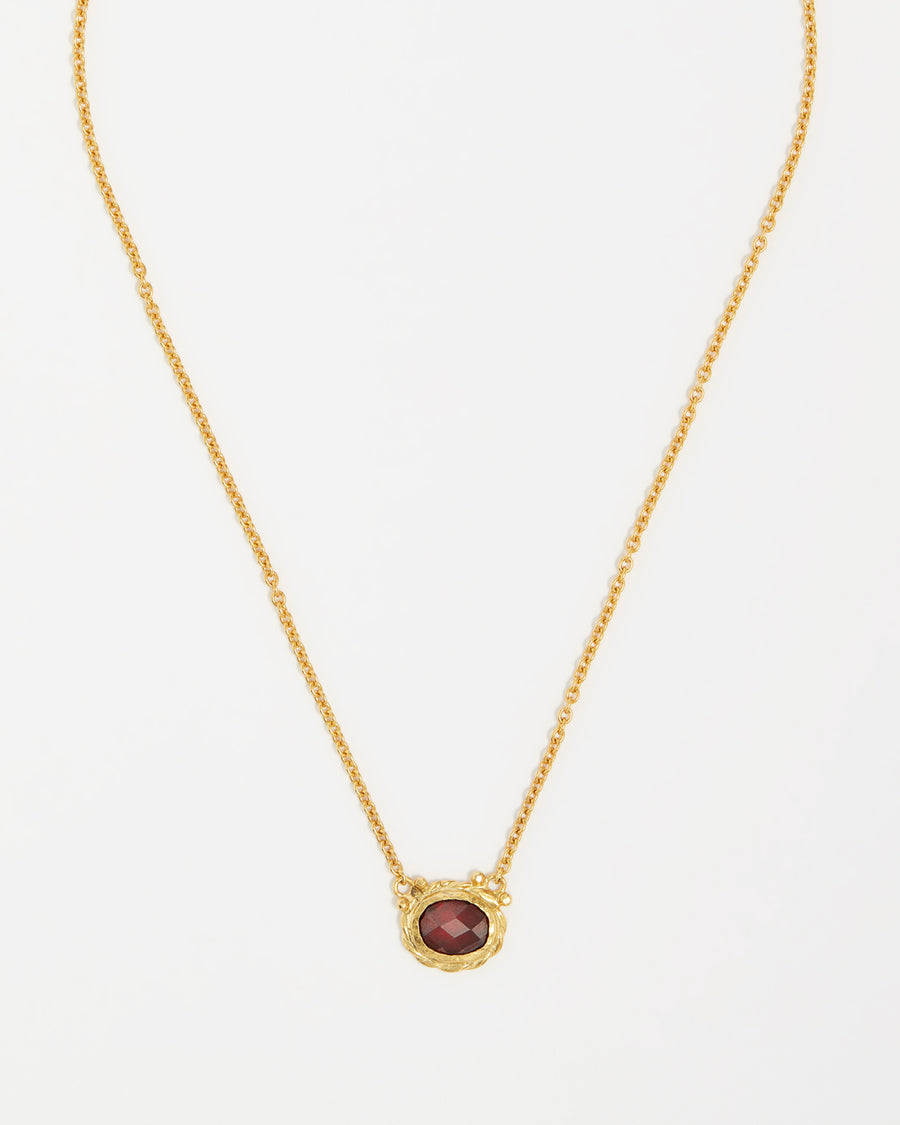 product shot of yellow gold plated silver necklace with a red crystal pendant