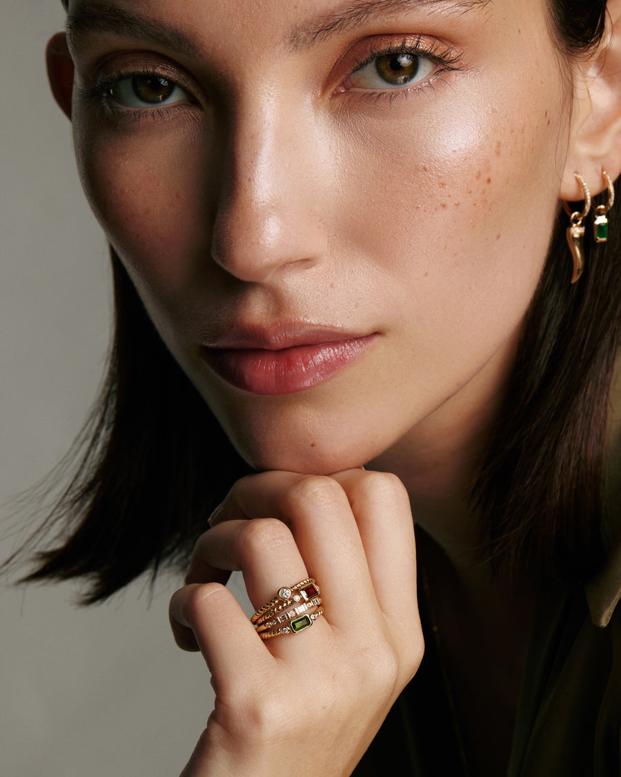 Soru Jewellery garnet and diamond gold ring stacked with other rings on models hand 