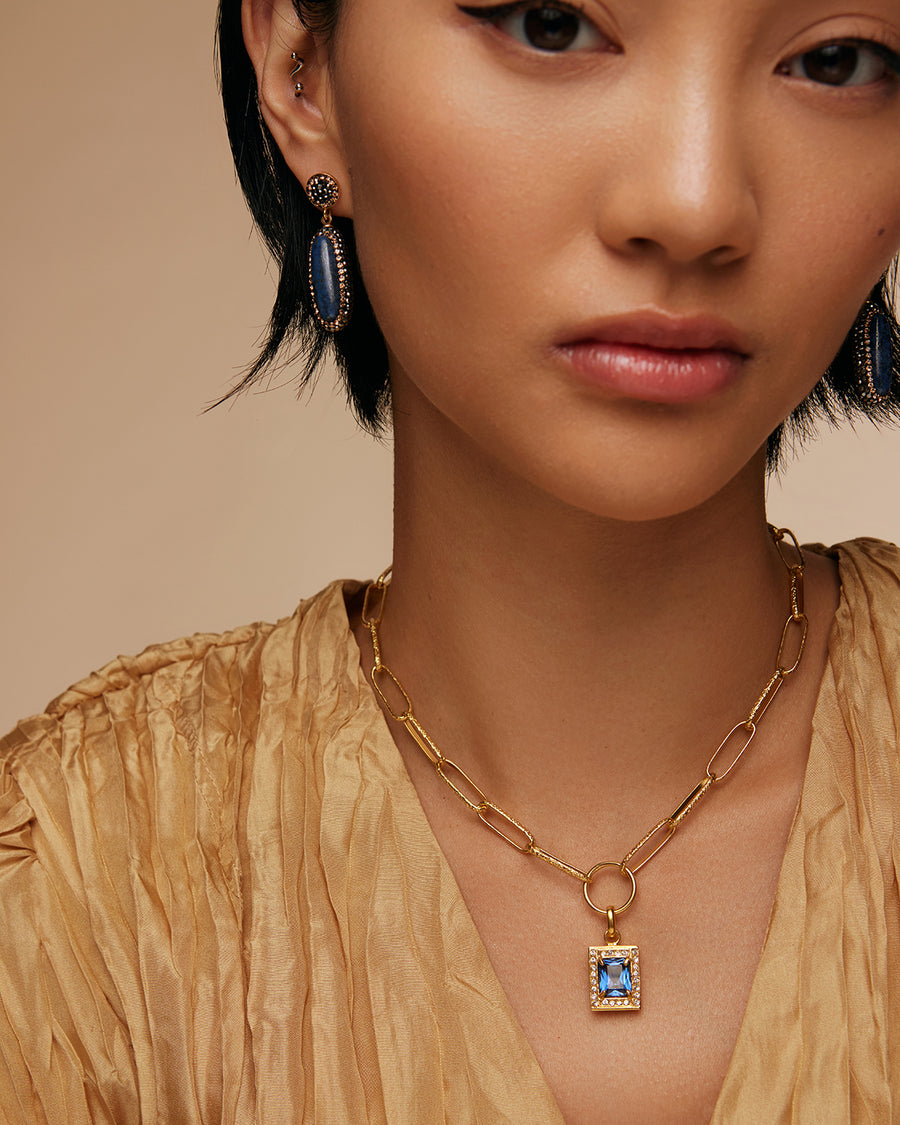 model shot of lapis long oval stone earrings surrounded by crystals