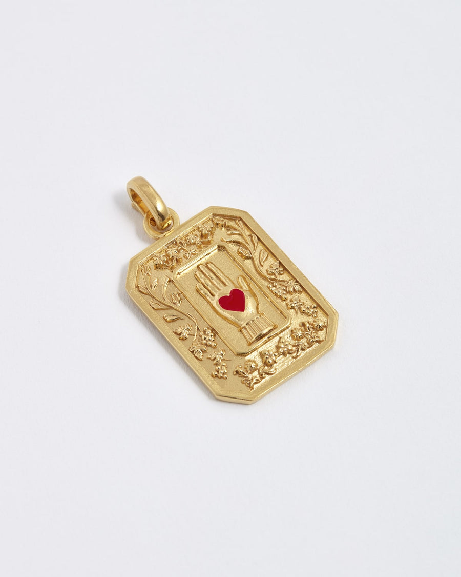 Soru Jewellery gold vintage style charm showing a red enamel heart in hand